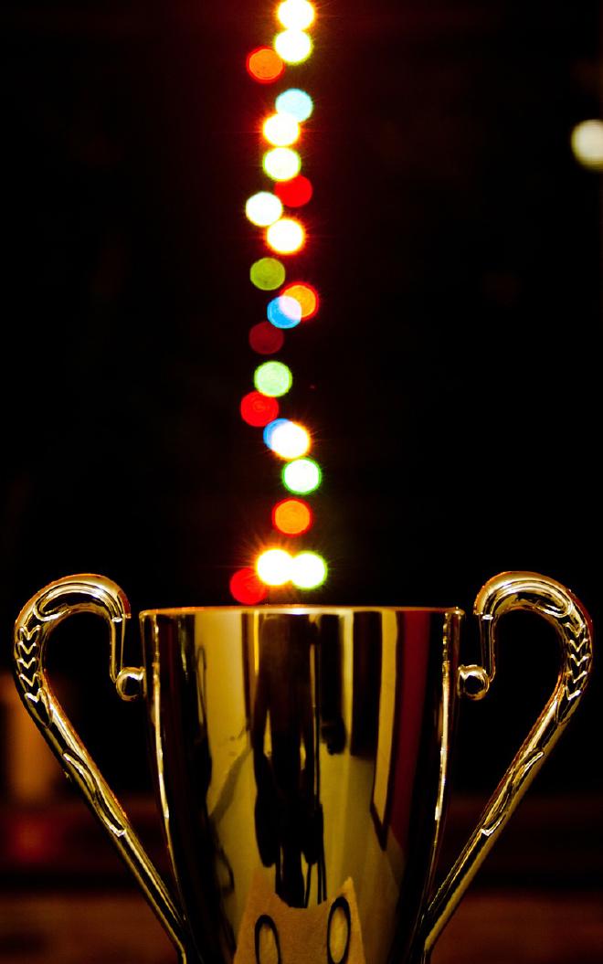 a shiny trophy with rainbow lights pouring out of it